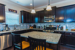 Open Kitchen with island, granite & glass tile backsplash at 1501 Wingate Park Court in New Park, Montgomery, AL. Professional photos and tour by Go2REasssistant.com