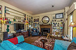 Cozy library with floor-to-ceiling bookcases and fireplace at 3225 East Audobon in historic Cloverdale, Montgomery, AL. Professional photos and tour by Go2REasssistant.com